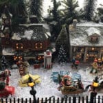 model of Victorian village with horse drawn sleigh snow buildings evergreens