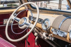 Old car interior with beige steering wheel & dashboard