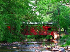 Esther Furnace Covered Bridge - red bridge over rocky stream surrounded by trees