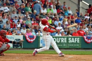 Hernandez hitting baseball with fans in stands behind