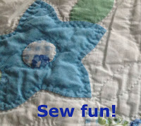 Closeup of portion of handmade quilt with blue flower and green leaf on white ground Text: sew fun!