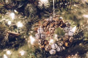 closeup of wreath of mini gold and white jingle bells on Christmas tree with white lights
