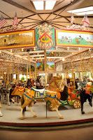 antique carousel with light and dark brown horses in museum