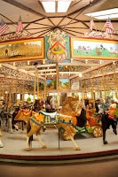 antique carousel with light and dark brown horses in museum