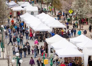 birds eye view of tops of white tents with crowds around them