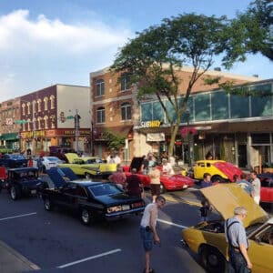 cars on display in street with downtown buildings in background