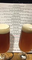 two glasses of draft beer poured sitting in front of menu at the Brew Pub