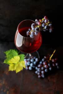 Glass of red wine with grapes by Roberta Sorge https://unsplash.com/@robertasorge