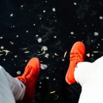Orange shoes and white pant legs on dark pavement by Shawn McKay on UnSplash https://unsplash.com/@smckay95