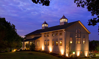 Turkey Hill Brewing Co post barn at night with two lighted cupulas and windows against darkening blue sky