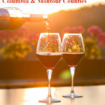 Closeup of bottle pouring red wine into two glasses on wood table with hill of autumn foliage in distance Text: October 6-15, 2017 Wine & Foliage Trail Columbia & Montour Counties