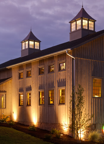 facade of turkey hill brewing company pole barn - brown vertical siding with two lighted cupulas