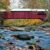 Covered bridge spanning a river with fall trees on either side.