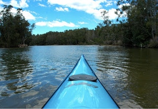 front of kayak floating on the river with beautiful blue skies