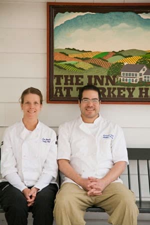 Matthew and Jen sitting on a bench outside the The Inn