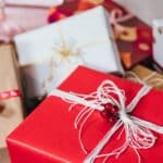 pile of gift packages wrapped in red and white papers with string ribbons