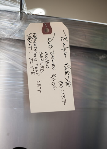 ticket labeled and hanging from canister of fresh brewed beer