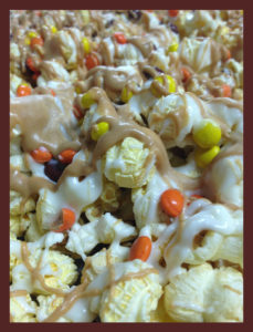 closeup of popcorn with milk & white chocolate drizzles and M&Ms