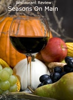 close up of glass of wine poured surrounded by fruits and vegetables of the season