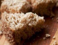 close up of sprouted flourless bread on wood cutting board