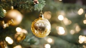 closeup of gold ornaments on a lighted christmas tree