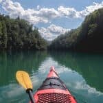 The front of a red kayak in a river