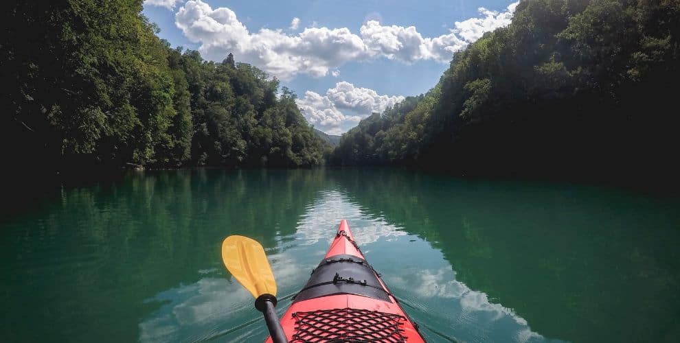 The front of a red kayak in a river