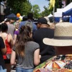 people crowding booths along busy Main St.