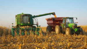 combine harvester unloading corn into a tractor trailer during harvest in a golden farm field