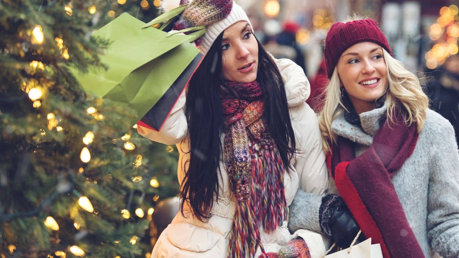 two ladies shopping at christmas with holiday decor background