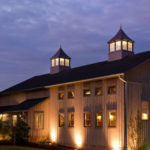 facade of turkey hill brewing company pole barn - brown vertical siding with two lighted cupulas
